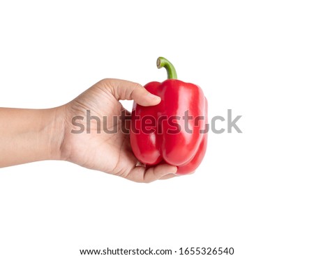 Woman hand holding a red bell pepper on a white background.