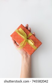 Woman Hand Holding Red Gift Box Isolated On White Background. Top View, Flat Lay. Copyspace