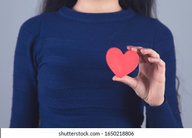 woman hand holding red heart on grey background - Shutterstock ID 1650218806