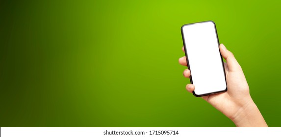 Woman Hand Holding  And Showing Smart Phone With Copy Space, Against Green Nature Outdoor. Social Media Mobile Concept. Banner