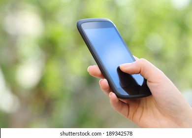 Woman Hand Holding A Smart Phone Outdoor With A Green Background