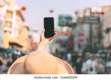 Woman Hand Holding A Smart Phone At Outdoor For Online Digital Application. Black Blank Device Screen For Copy Space. Urban Lifestyle Background.