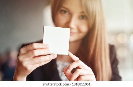 Woman hand holding square blank clean sticker mock up. Close up background place for text