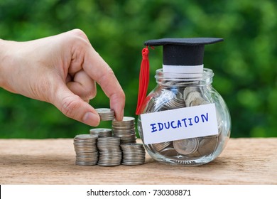 Woman Hand Holding Stack Of Coins Money And Glass Jar With Full Of Coins And Graduates Hat Label As Education, Education Or Savings Concept.