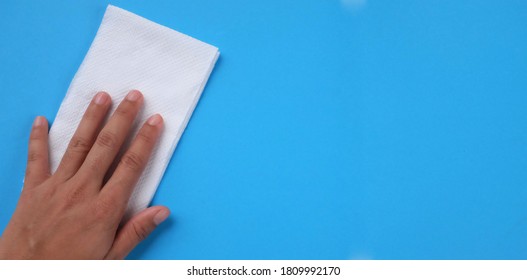 woman Hand holding tissue paper on a blue background