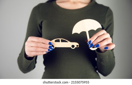 Woman Hand Holding Wooden Umbrella Over Car, Symbol For Car Protection

