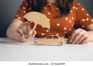 Woman Hand Holding Wooden Umbrella Over Car, Symbol For Car Protection

