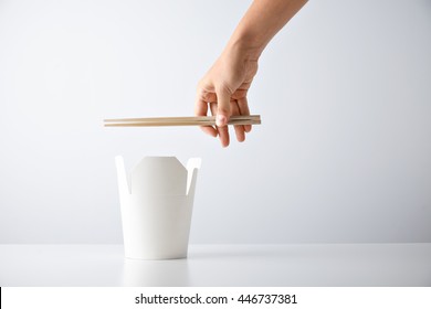 Woman Hand Holds Chopsticks Above Opened Blank Takeway Box With Tasty Noodles Isolated On White Retail Set Presentation Mockup