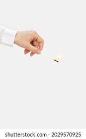 Woman Hand Holds Lit Match On White Background. Wooden Matchstick Is Burning. Fire Hazard Concept.