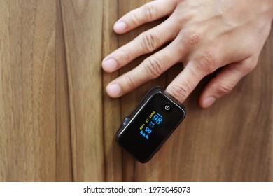 Woman hand introduced in a oximeter to check oxygen levels and pulse because Covid-19 pandemic. 
