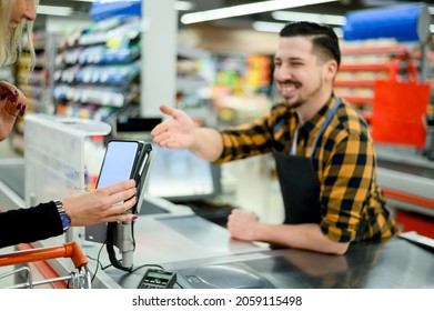 Woman hand making a contactless payment with her credit card at a supermarket - Shutterstock ID 2059115498