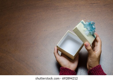 Woman Hand Open Gift Box On Wooden Background With Copy Space
