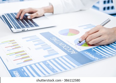 woman hand with pen and business report - Shutterstock ID 386112580