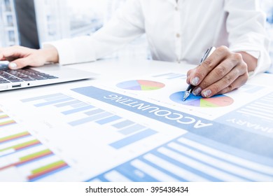 woman hand with pen and business report - Shutterstock ID 395438434