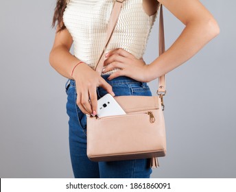 Woman hand phone on bag pocket.