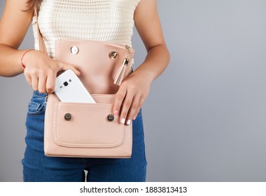 Woman hand phone on bag pocket.