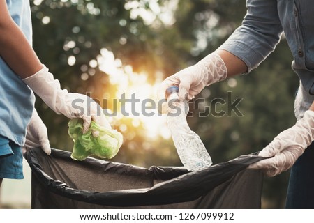 woman hand picking up garbage plastic for cleaning at park