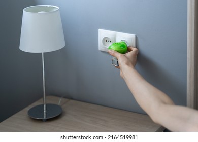 Woman Hand Plugs Mosquito Repellent Into The Socket Before Going To Bed. Domestic Electric Raptor Fumigator For Mosquitoes Protection At Home. 