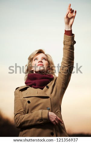 Woman with a hand pointing in the sky