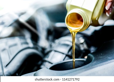 Woman Hand Pour Motor Oil To Car Engine. Vehicle Maintenance And Top Up Fluids And Change Liquids In Service.