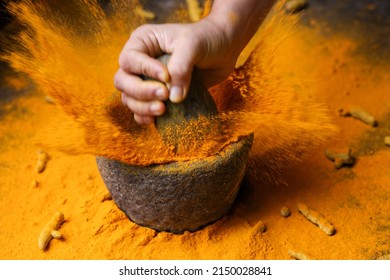 Woman hand powdering Indian spices turmeric powder splash explosion stone mortar Kerala India Sri Lanka traditional Indian kitchen Masala for curry, antiseptic antiviral Ayurvedic medicine. - Powered by Shutterstock