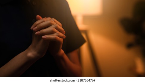 woman hand praying with magic light that flows through on orange bokeh background. - Shutterstock ID 2187654769