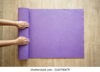 Woman hand preparing yoga mat at home on the floor. Be ready to exercise at home. - Powered by Shutterstock