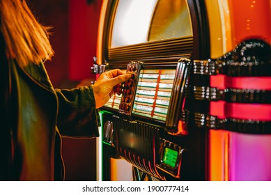 Woman Hand Pushing Buttons To Play Song On Old Jukebox, Selecting Records