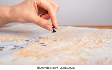 Woman hand pushing pin on map. Trip planning. Female marking travel destination, location with pushpin. Adventure, navigation, logistics concept. High quality photo - Shutterstock ID 2201600989