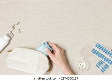 Woman Hand Put Medicine Dose Box With Pills In Cosmetic Bag. Pill Box For Daily Taking Medicine, Tablets And Capsules. Medication As Alternative Medicine For Treatment And Good Health, Medical Flatlay