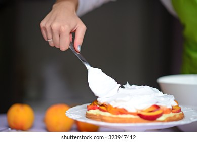 Woman Hand Put Whipped Cream On The Cake Crust