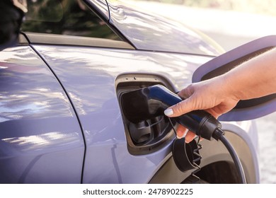 Woman hand puts the car on EV charging. Electric car - Powered by Shutterstock