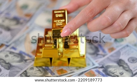 Woman hand puts golden ingot of dollar banknote. Favorable investment interest and deposit and financial income