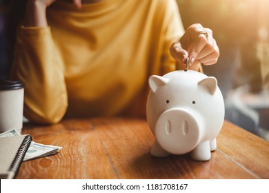 woman hand putting money coin into piggy for saving money wealth and financial concept.