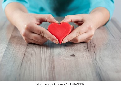 woman hand red heart on the table