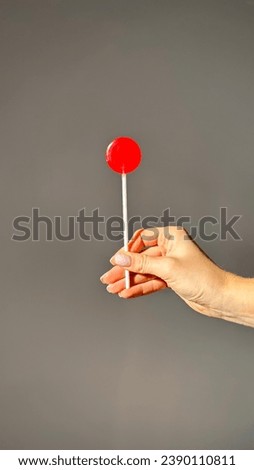 woman hand with red lollipop isolated