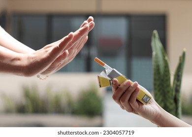 La mano de una mujer rechaza un cigarrillo. El concepto de dejar de fumar, Día Mundial sin Tabaco.