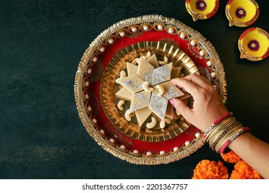 Woman Hand Serving Kaju Barfi Or Cashew Fudge Candy.  Indian Sweet For Diwali Festival. India Festivals Like Dussehra Holi Ganesh Chaturthi Ram Navmi Ramadan Pakistan India Sri Lanka Kerala