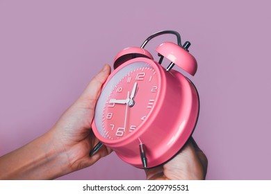 Woman Hand Is Setting Pink Alarm Clock 