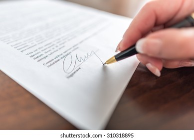 Woman hand signing a contract - Shutterstock ID 310318895