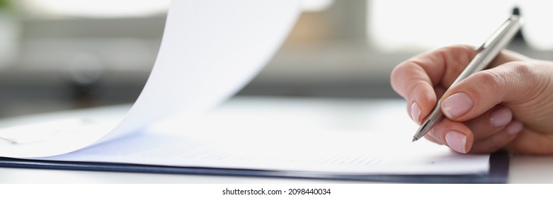 Woman Hand Signing Documents On Clipboard With Ballpoint Pen Closeup. Conclusion Of Contracts And Transactions Concept