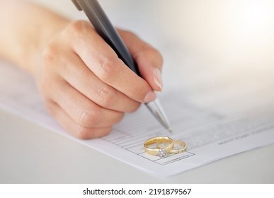 .Woman Hand Signing Legal Divorce Documents, Deal Or Paper Contract In A Lawyer Office With Ring Placed On Table. Person Writing Signature On Marriage Paperwork After Agreement At Family Law Office.