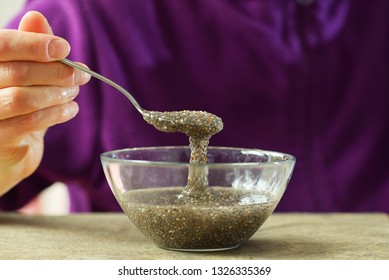 Woman Hand With Spoon Of Chia Seeds In Water