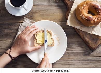 Woman Hand Spreading Butter On Sliced Bread