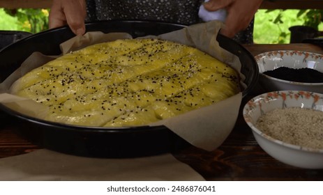 Woman Hand Sprinkle Sesame Seed to the Top of Bread Dough, Baking Process in the Kitchen Making Delicious Bread or Pizza - Powered by Shutterstock