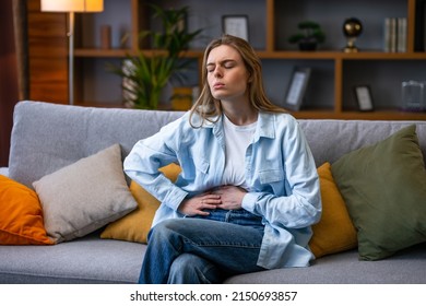 Woman hand in stomach ache, suffer from food poisoning, abdominal pain and colon problem, gastritis. Patient belly, abdomen or inflammation, concept. - Shutterstock ID 2150693857