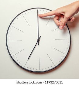 Woman Hand Stop Time On Round Clock, Female Finger Takes The Minute Arrow Of The Clock Back, Time Management And Deadline Concept 