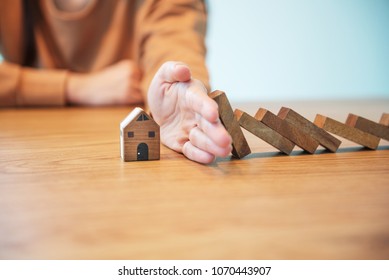 Woman Hand Stopping Risk The Wooden Blocks From Falling On House, Home Insurance And Security Concept.