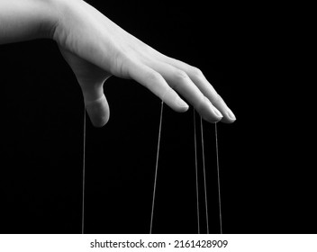 Woman hand with strings on fingers. Manipulation, control concept. Female suffering from blaming, shaming, abuse. Black and white. High quality photo