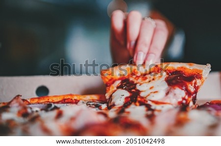 woman Hand takes a slice of chicken Pizza in paper box in cafe